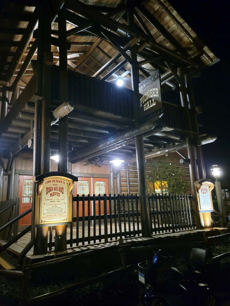 Outside exterior picture of pioneer hall. it's night time and it looks quaint and rustic Hoop-De-Doo Musical Revue