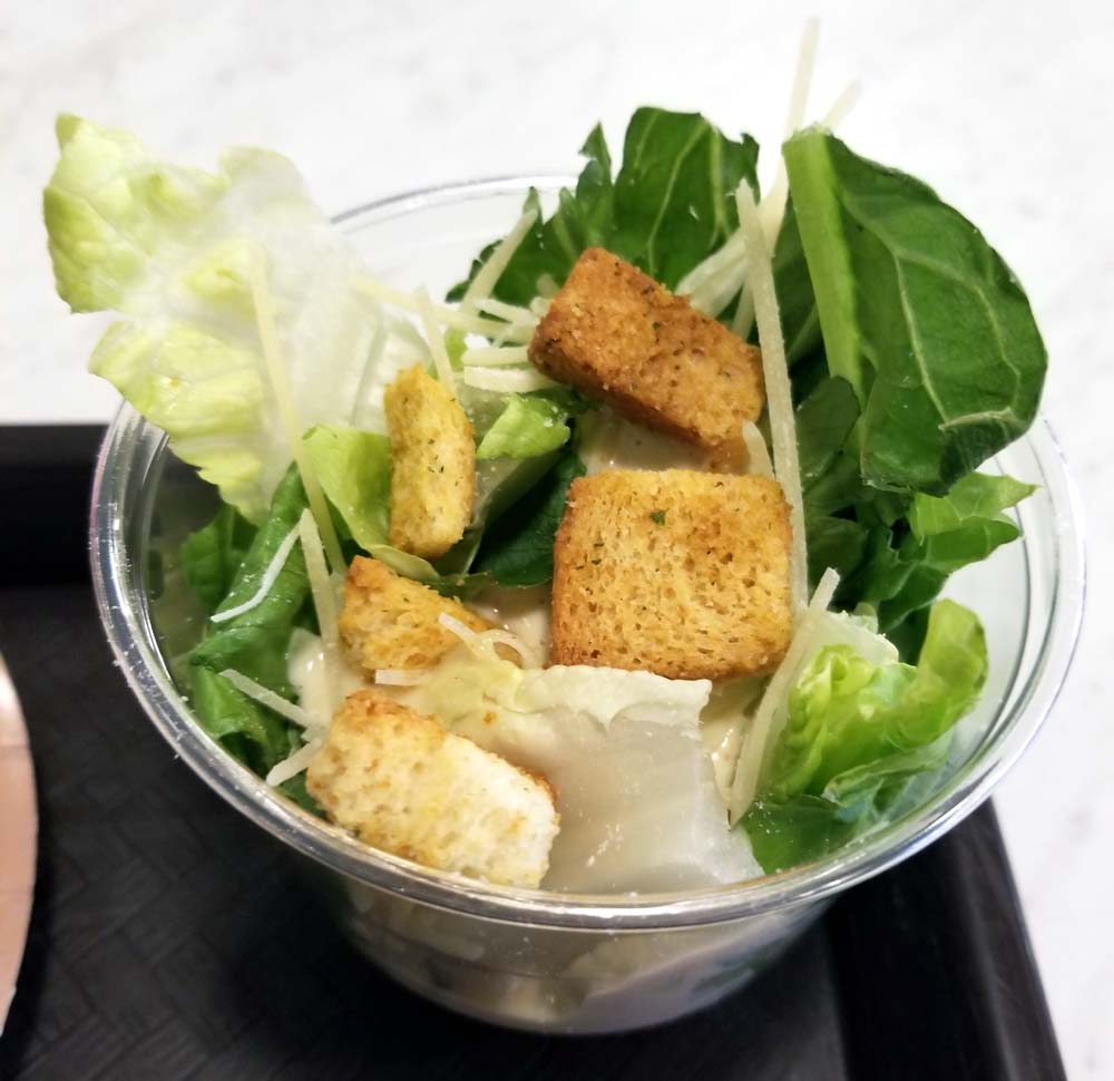 an offensively small caesar side salad, served in a plastic drink cup at PizzeRizzo
